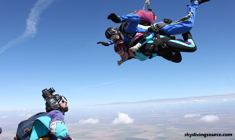 A videographer filming a tandem skydive