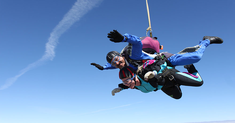 vrouw die een tandem skydive doet